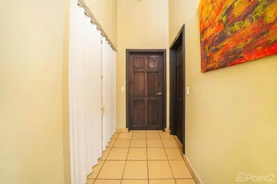 a hallway with a door and a painting on the wall at Beautiful 2-BR House Steps from the Beach in Playa Flamingo