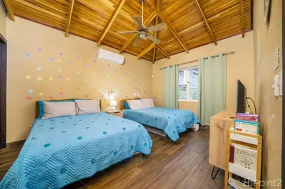 a bedroom with two beds and a ceiling fan at Beautiful 2-BR House Steps from the Beach in Playa Flamingo