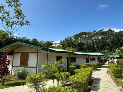 a house with a green roof and bushes at Bambura Bahia Villas in Uvita