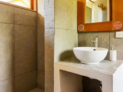 a bathroom with a white sink and a shower at Bambura Bahia Villas in Uvita