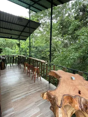 a wooden deck with a table and chairs and trees at Montana Log Cabin in Rivas
