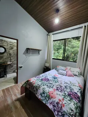 a bedroom with a bed and a large window at Montana Log Cabin in Rivas