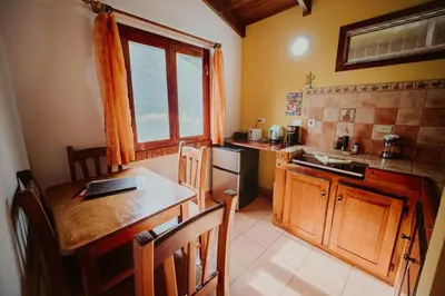 a kitchen with a wooden table and a counter top at Lodge Mirador - Great Swimming pool - Kitchen - BBQ - Netflix in Tajo Alto