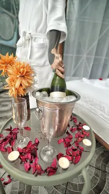 a woman is holding a bottle on a table with flowers at Lodge Mirador - Great Swimming pool - Kitchen - BBQ - Netflix in Tajo Alto