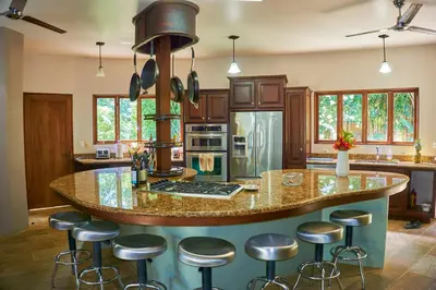 a kitchen with a large island with bar stools at Manoas in Uvita
