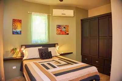 a bedroom with a bed and a dresser at Manoas in Uvita