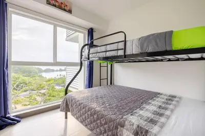 a bedroom with two bunk beds and a window at Ocean View steps to the beach in Punta Leona