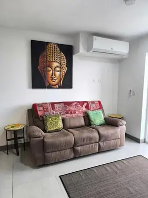 a brown couch in a living room with a painting at Ocean View steps to the beach in Punta Leona