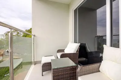a balcony with wicker chairs and a table at Ocean View steps to the beach in Punta Leona
