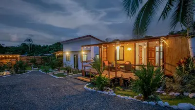 a wooden house with a porch at night at Villa Palmera-Fortuna in Fortuna