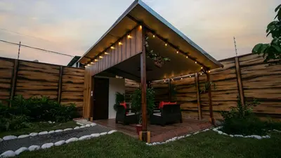 a wooden house with a deck with chairs and lights at Villa Palmera-Fortuna in Fortuna