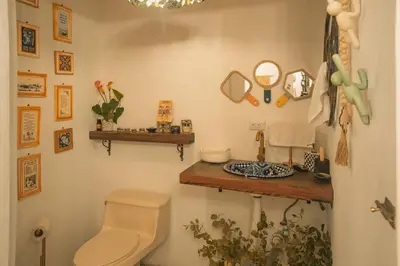 a bathroom with a toilet and a wooden shelf at Cuki House in Quesada