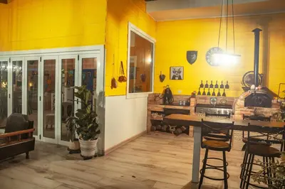 a kitchen with yellow walls and a table and chairs at Cuki House in Quesada