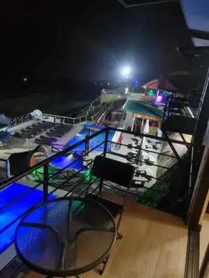 a table and chairs on a balcony at night at Hotel Bar Restaurante IL Rifugio in Poás