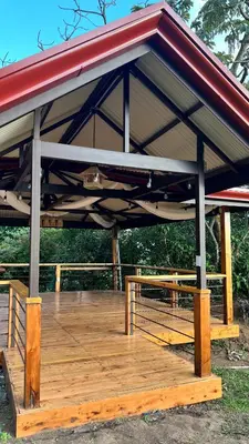 a pavilion with a wooden deck with a red roof at Hotel Bar Restaurante IL Rifugio in Poás