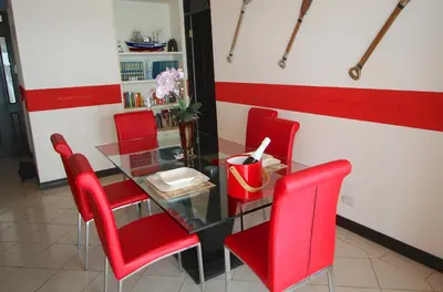 a dining room with red chairs and a glass table at The Lighthouse Ocotal in Coco