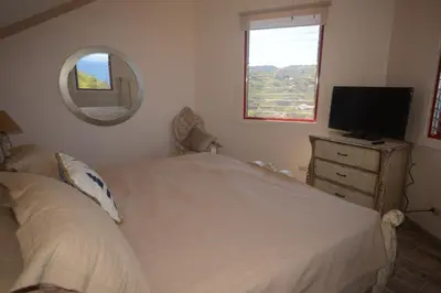 a bedroom with a bed and a tv and a mirror at The Lighthouse Ocotal in Coco