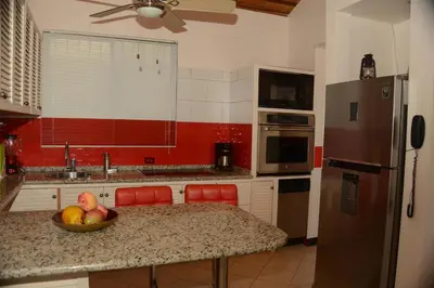 a kitchen with a bowl of fruit on a counter at The Lighthouse Ocotal in Coco