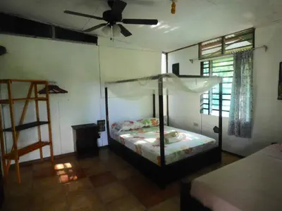 a bedroom with a bed and a ceiling fan at Cabinas del Mar in Sámara