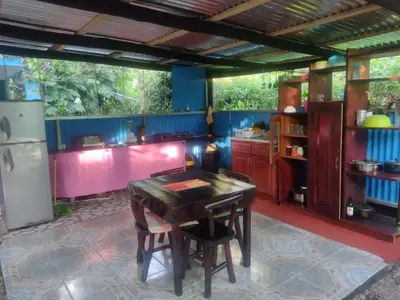 a kitchen with a wooden table and a refrigerator at Cabinas del Mar in Sámara