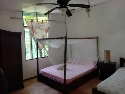 a bedroom with a bed with a ceiling fan at Cabinas del Mar in Sámara