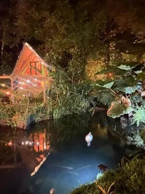 a pond in front of a house at night at Tipi Cabécar in Heredia