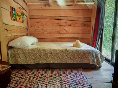 a bedroom with a bed in a log cabin at Tipi Maleku in Heredia
