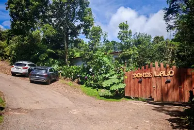 a car parked next to a fence with a yard load sign at Tipi Maleku in Heredia