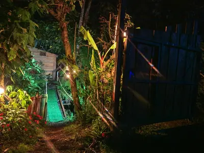 a garden at night with a blue fence at Tipi Maleku in Heredia
