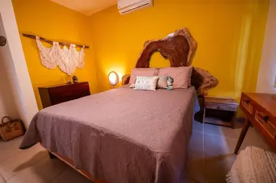 a bedroom with a large bed with yellow walls at Villa Cascada by Vacation Pura Vida in Esterillos