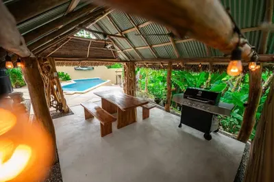 an outside view of a house with a table and a piano at Villa Cascada by Vacation Pura Vida in Esterillos