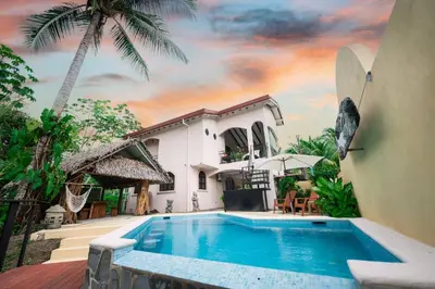 a villa with a swimming pool in front of a house at Villa Cascada by Vacation Pura Vida in Esterillos