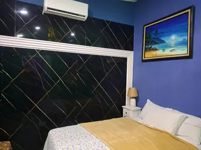 a bedroom with a bed with a black wall at Brand New Descanso del Perezoso in Manuel Antonio