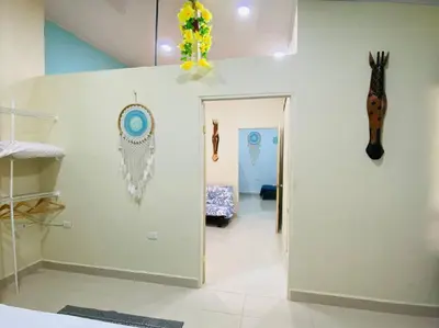 a hallway with a door to a room with a giraffe on the wall at Brand New Descanso del Perezoso in Manuel Antonio