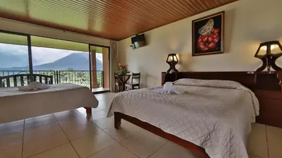 a bedroom with two beds and a balcony with a view at Hotel Linda Vista in Fortuna