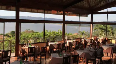 a dining room with tables and chairs and windows at Hotel Linda Vista in Fortuna