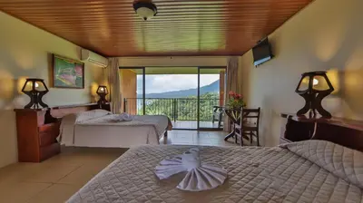a hotel room with two beds and a balcony at Hotel Linda Vista in Fortuna