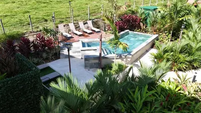 a pool with a table and benches in a garden at Fortuna Retreat in Fortuna