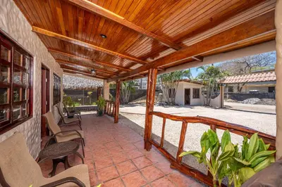 a porch with chairs and a wooden roof at BP Surf Hotel in Playa Grande