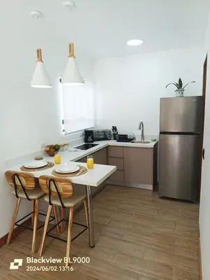 a kitchen with a table and chairs and a refrigerator at Valu in Puntarenas