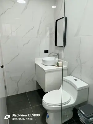 a white bathroom with a toilet and a sink at Valu in Puntarenas