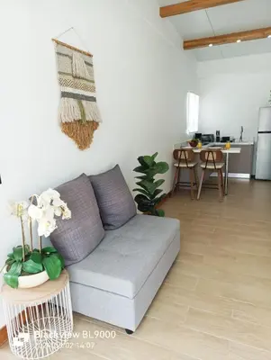 a living room with a gray couch and a kitchen at Valu in Puntarenas