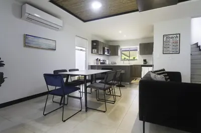 a dining room and kitchen with a table and chairs at Ciudad del Mar 126 condo in Jacó