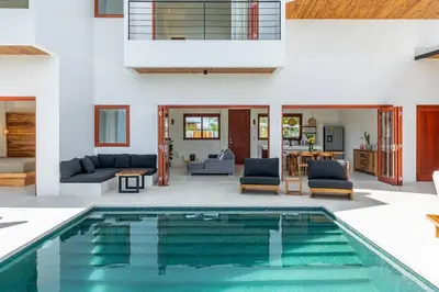 a house with a swimming pool in a living room at Elegant Ocean View Villa Serena in Cóbano