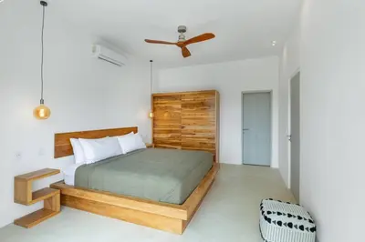 a bedroom with a bed and a ceiling fan at Elegant Ocean View Villa Serena in Cóbano