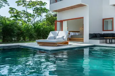 a villa with a swimming pool in front of a house at Elegant Ocean View Villa Serena in Cóbano
