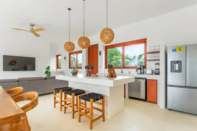 a kitchen with a counter and some chairs in a room at Elegant Ocean View Villa Serena in Cóbano