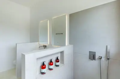 a bathroom with four coca cola bottles on a wall at Elegant Ocean View Villa Serena in Cóbano