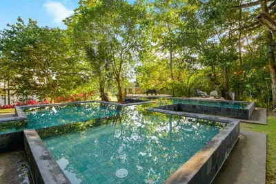 a pool with blue water in a yard with trees at Arcadia Condo In Místico, Playa Hermosa in Playa Hermosa