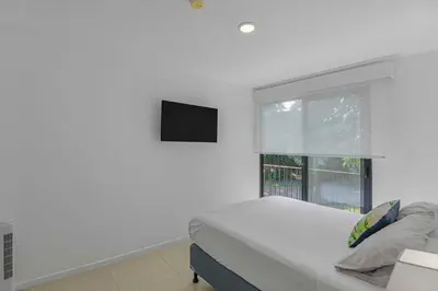 a white bedroom with a bed and a window at Arcadia Condo In Místico, Playa Hermosa in Playa Hermosa